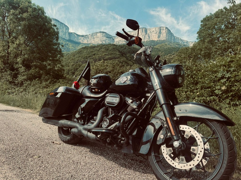 Black Harley Road King Special parked on a mountain road with dramatic limestone cliffs in the background