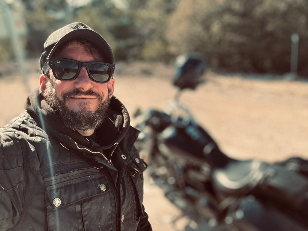 Joshua James, founder of Wild Roads Motorcycle Tours, with his Harley in the background