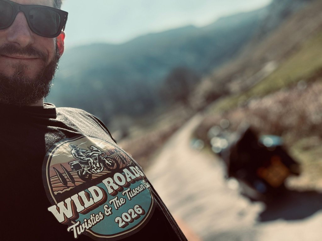 Wild Roads Twisties and The Tuscan Sun 2026 tour badge on a riding jacket in the mountains