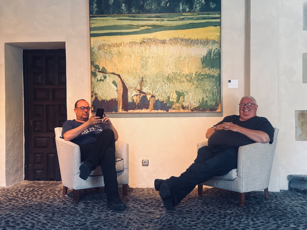 Two Wild Roads riders relaxing in armchairs Parador de Gil Blas Santillana del Mar — Picos & Pyrenees May 2026