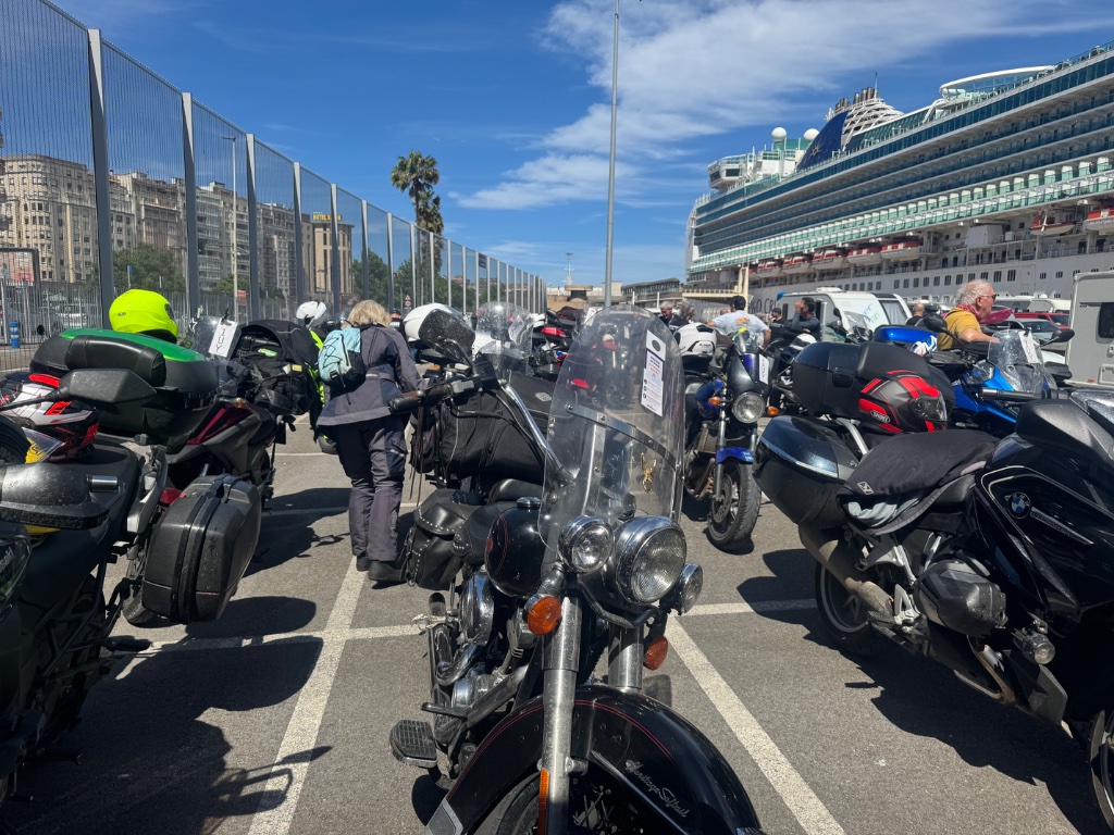 Motorcycles queued at Santander ferry terminal cruise ship in background — Picos & Pyrenees May 2026