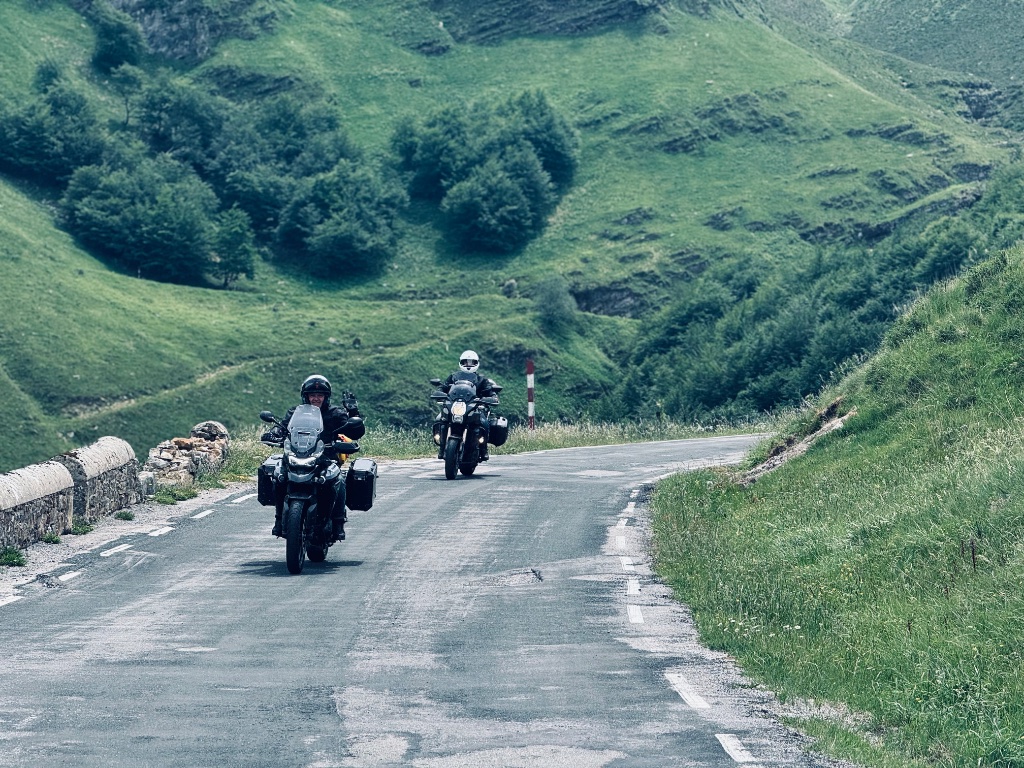 Two Wild Roads riders coming up narrow Pyrenean mountain pass road — Picos & Pyrenees May 2026