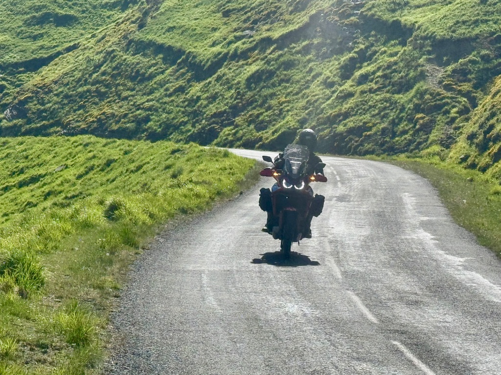 Honda Africa Twin head-on on narrow Pyrenean mountain road — DRL headlights on — Wild Roads May 2026