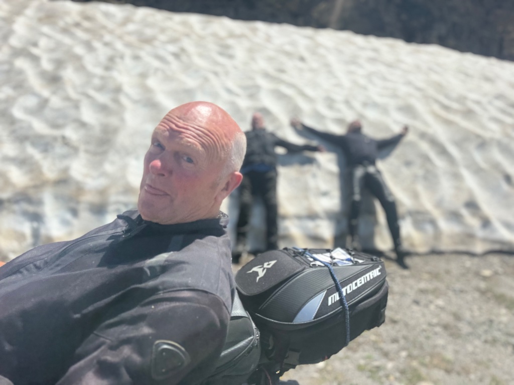 Rider selfie with two riders posing against snow bank — Pyrenees — Wild Roads Picos & Pyrenees Tour May 2026
