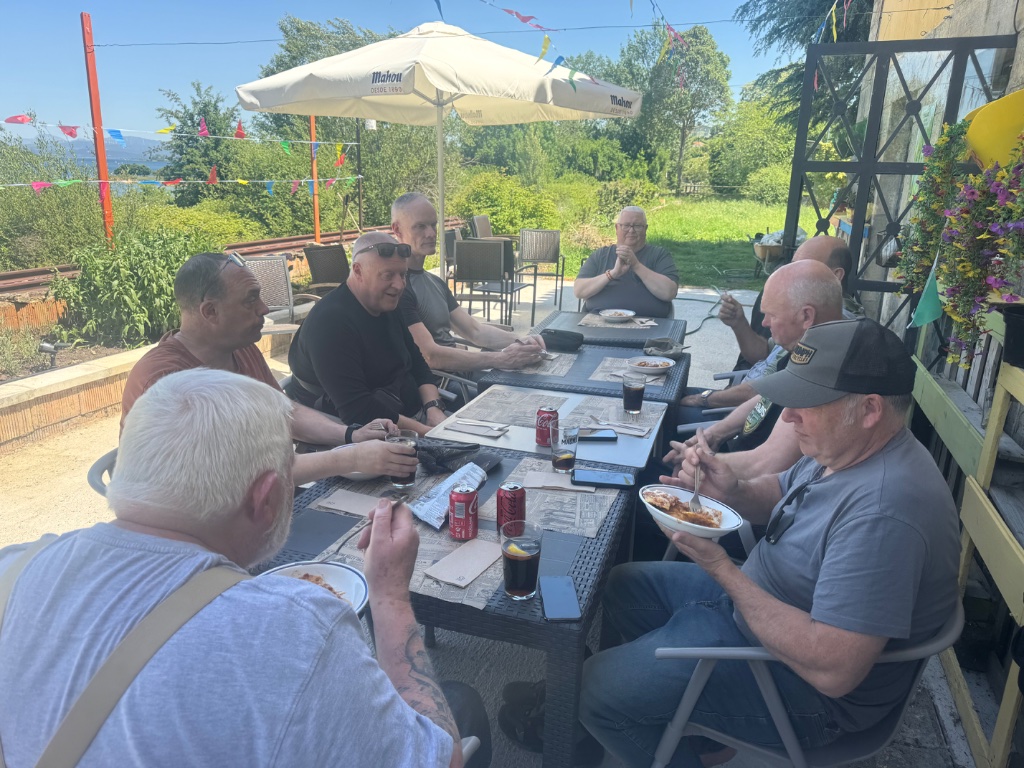 Wild Roads full group lunch at lakeside terrace restaurant Las Rozas de Valdearroyo Spain — Picos & Pyrenees May 2026
