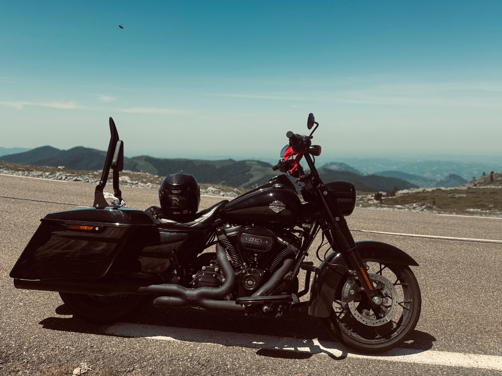 Harley-Davidson Road King Special at Pyrenean summit — wide mountain ridgeline behind — Wild Roads May 2026
