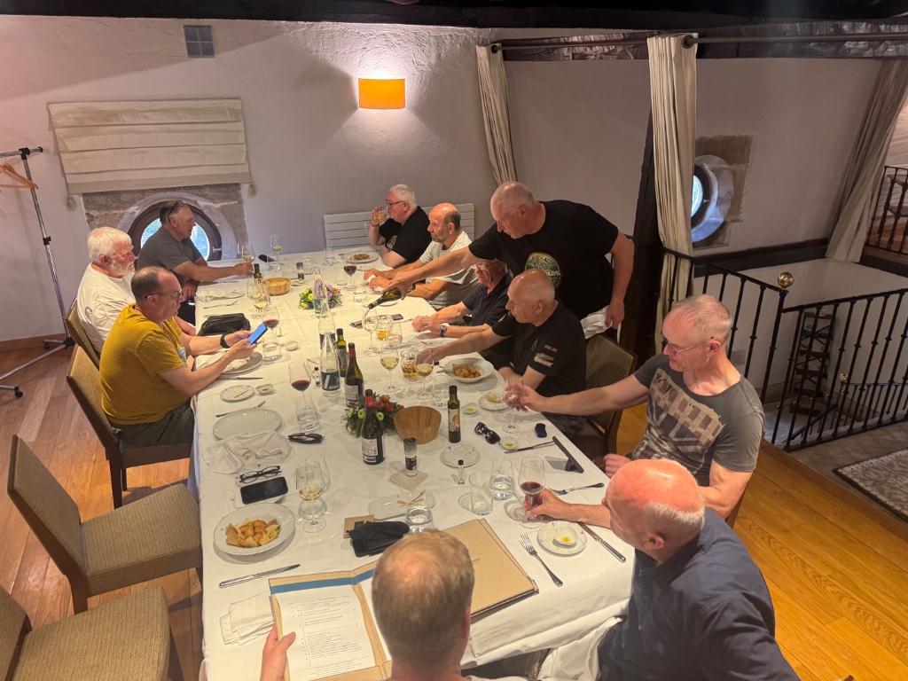 Wild Roads farewell group dinner at Parador de Argomaniz — full group around dining table with wine — Picos & Pyrenees May 2026