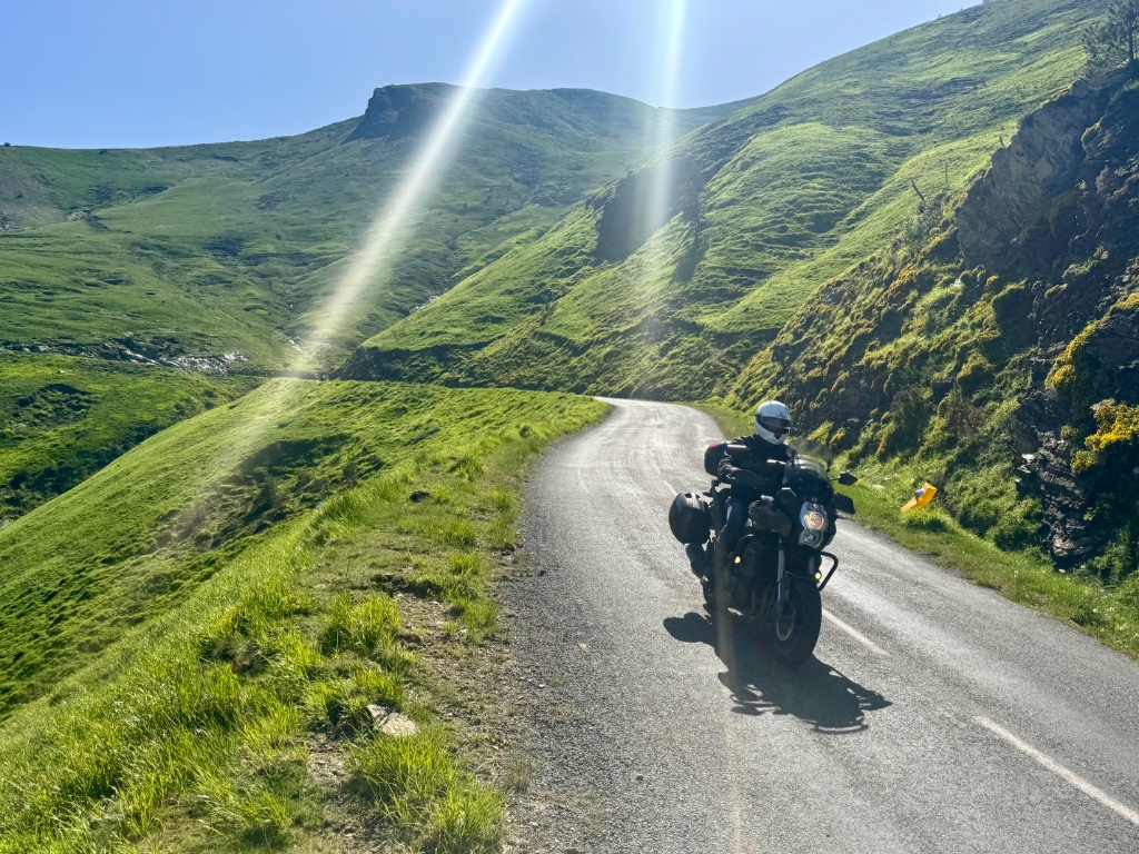 Motorcycle climbing narrow twisting mountain road near Larrau Pass — Pyrenees — Wild Roads May 2026