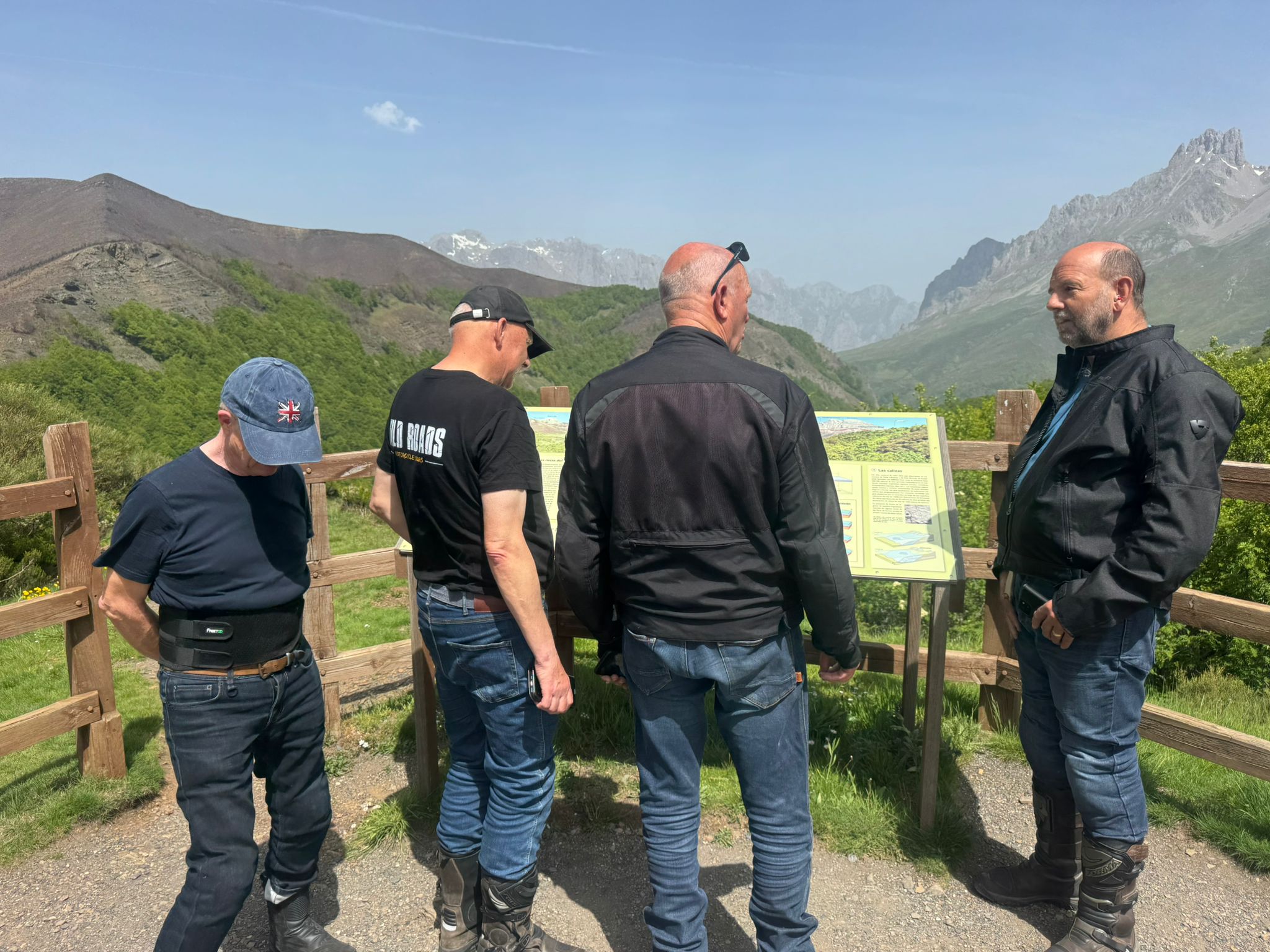 Wild Roads group at a Picos de Europa viewpoint reading the mountain information board