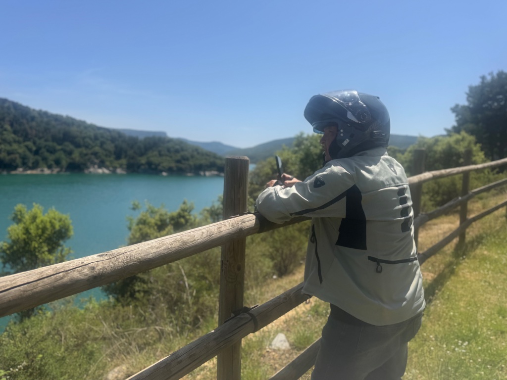 Rider photographing turquoise mountain lake in the Basque Country — Wild Roads Picos & Pyrenees May 2026