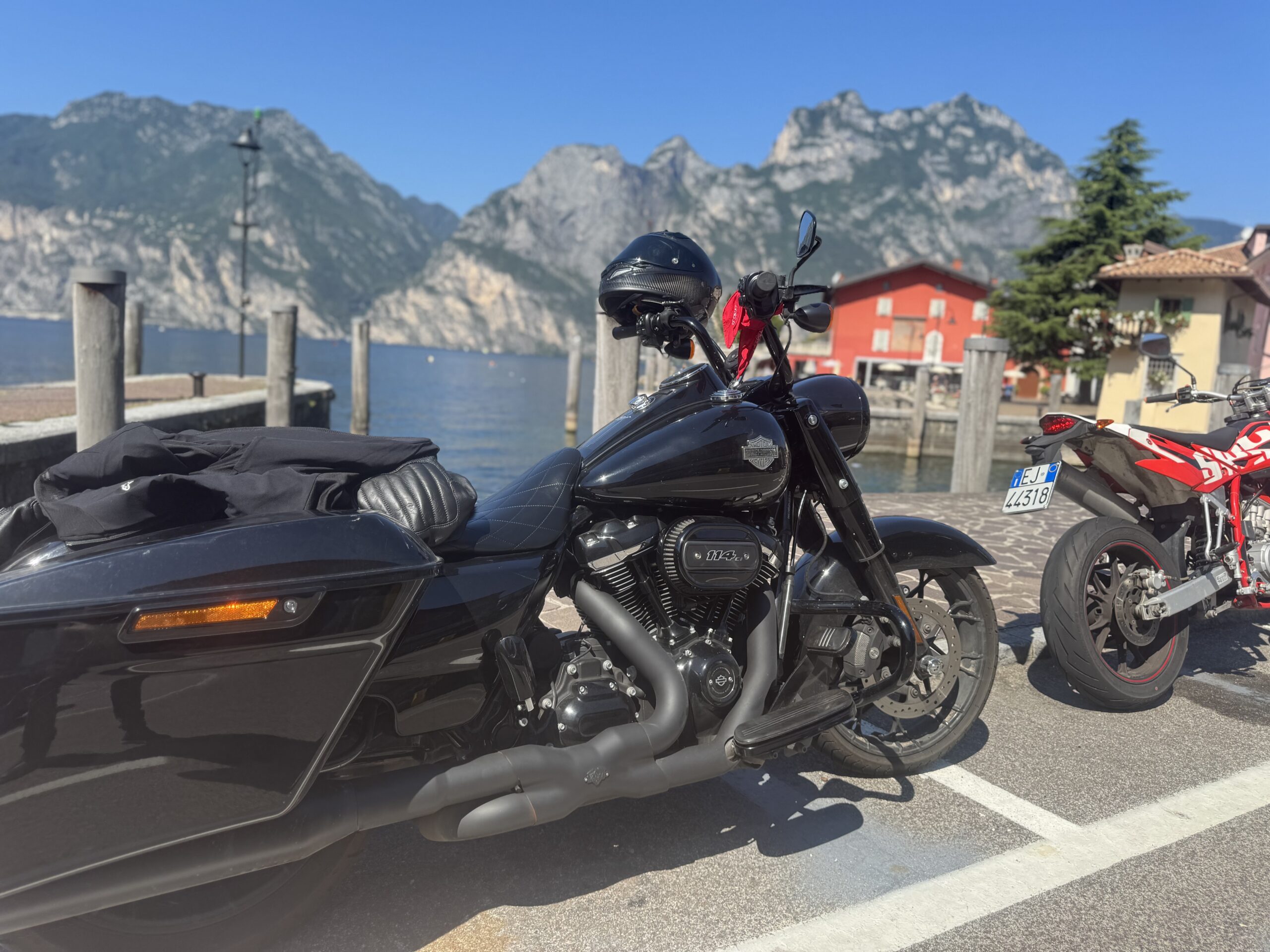 Motorcycles parked in Torbole on the north shore of Lake Garda with towering mountains in the background