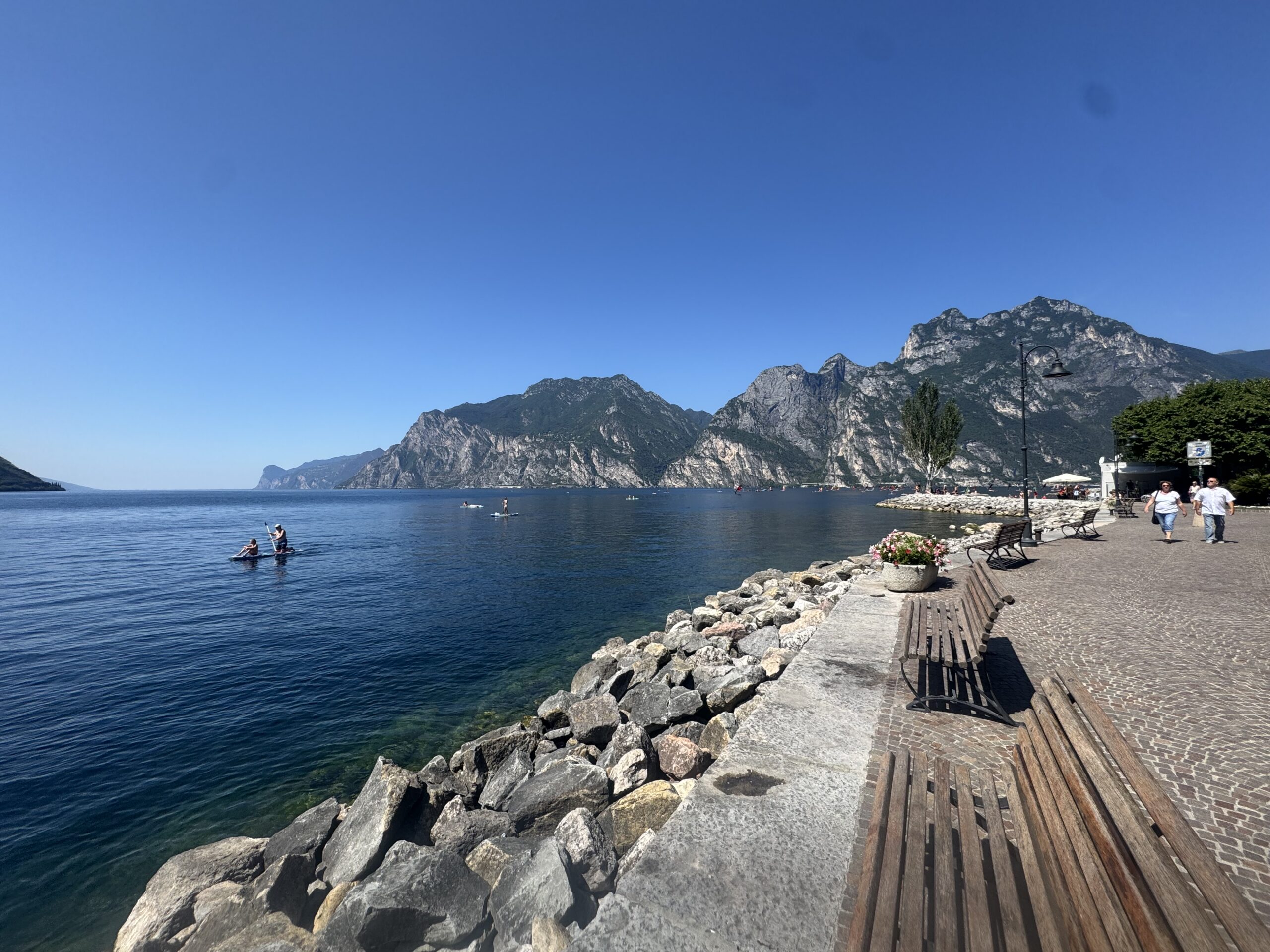 Breathtaking view of Lake Garda waters framing the surrounding Alpine mountains at Torbole