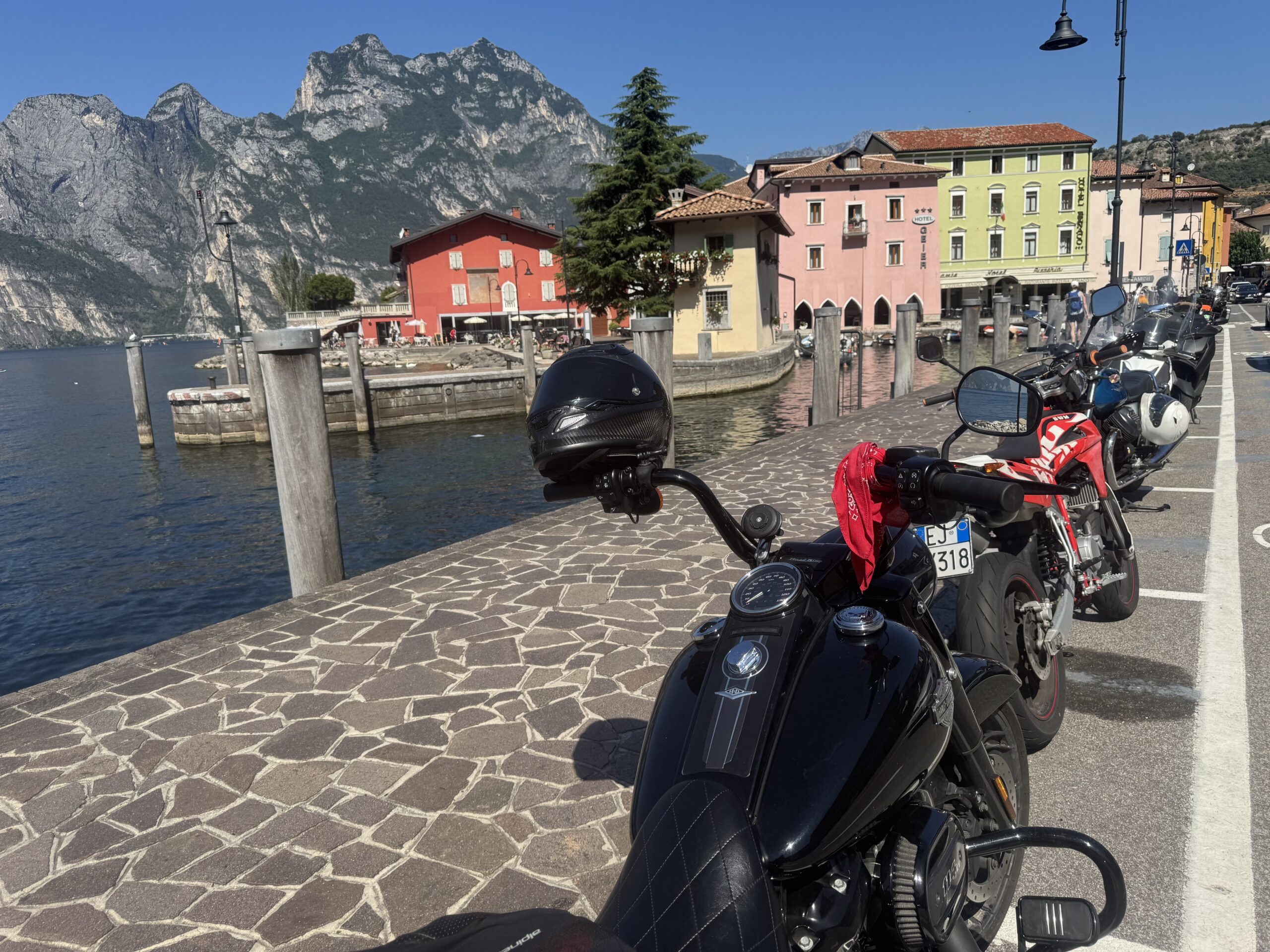 Wild Roads touring group motorcycles lined up near the waterfront at Torbole